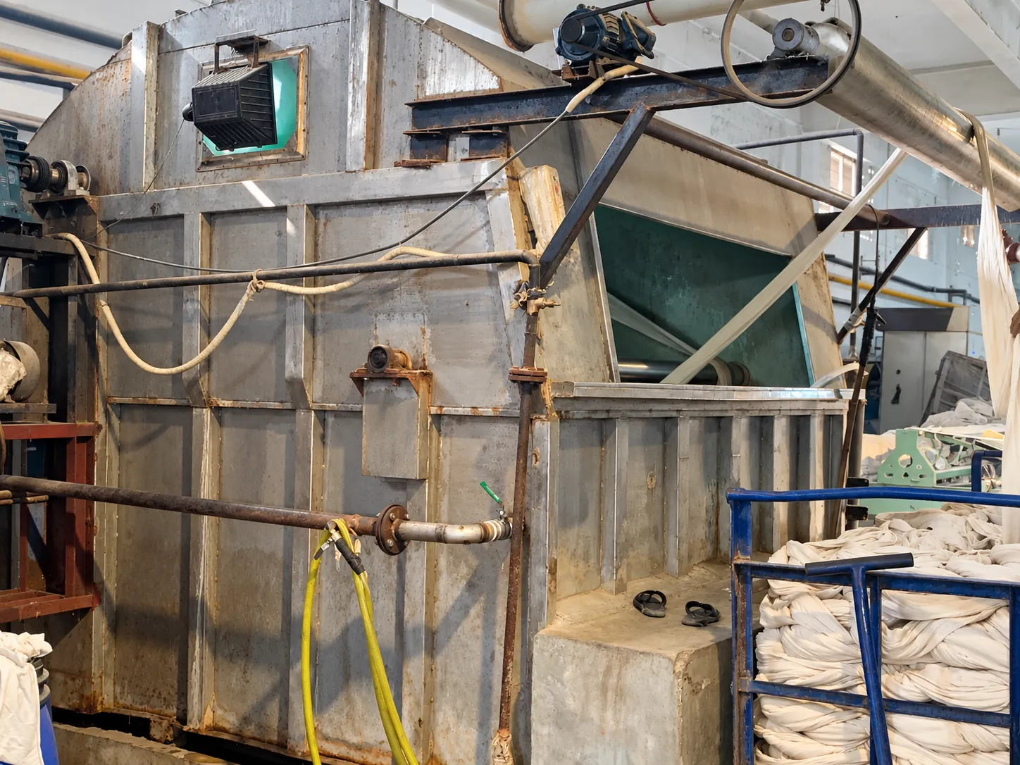 Fabric processing equipment Fabric processing equipment with a trolley of fabric.