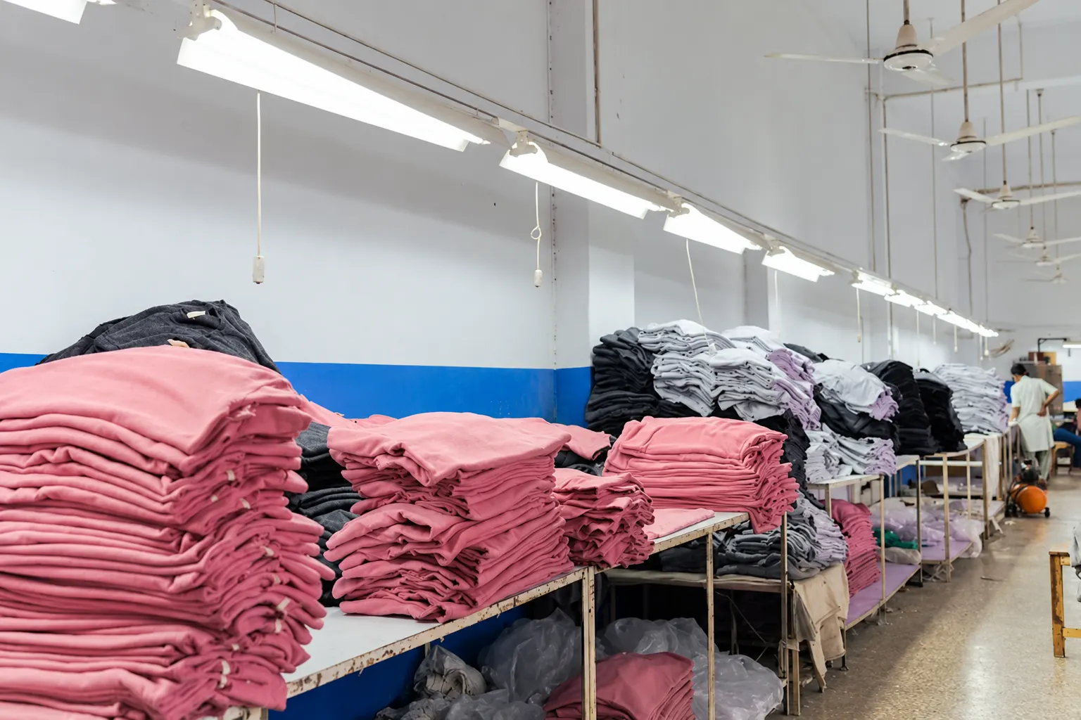 Production batches Stacks of coloured textile batches arranged on production tables.
