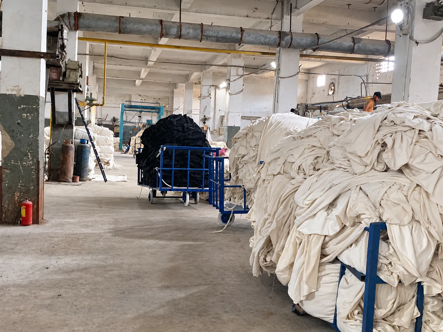 Fabric processing area Fabric batches on trolleys inside the textile processing facility.